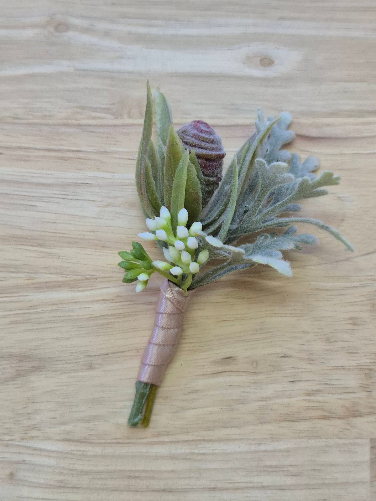Artificial wedding boutonniere with a grey faux protea bud, pale narrow leaves, rounded eucalyptus and blush-wrapped stems. For formals, proms and ball occasions. Made in Melbourne by Flowers For Ever After, shipping Australia and Worldwide.