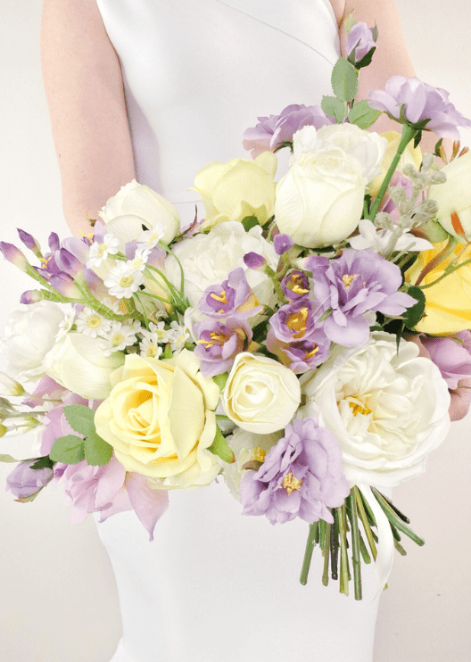 Artificial wedding bouquet close-up with lilac and yellow faux roses, white peonies and purple flower spikes. Made in Melbourne by Flowers For Ever After, shipping Australia and Worldwide.