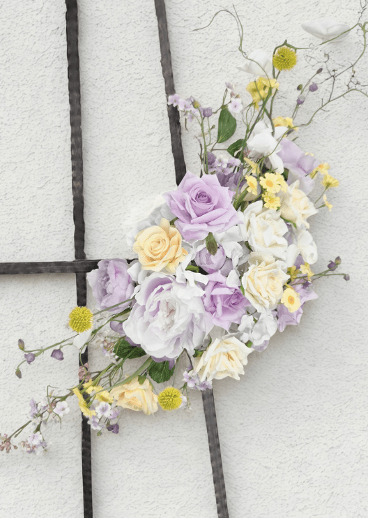 Artificial wedding smaller arbor floral spray with lilac and cream faux roses, white hydrangea, yellow pompom flowers and fine branching stems. Made in Melbourne by Flowers For Ever After, shipping Australia and Worldwide.