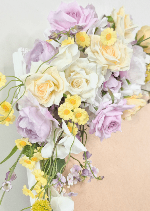 Artificial wedding sign flower close-up with lilac and cream faux roses, white blooms, small yellow flowers and lilac blossoms. Made in Melbourne by Flowers For Ever After, shipping Australia and Worldwide.