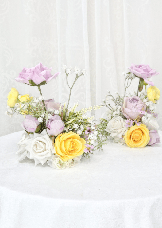 Artificial wedding pair of small table arrangements with lilac, yellow and white faux roses and fine branching flower sprigs. Made in Melbourne by Flowers For Ever After, shipping Australia and Worldwide.