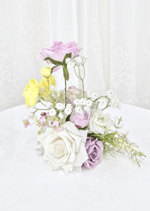Artificial wedding small table arrangement, reverse view of lilac and white faux roses, yellow blooms and fine white sprigs. Made in Melbourne by Flowers For Ever After, shipping Australia and Worldwide.