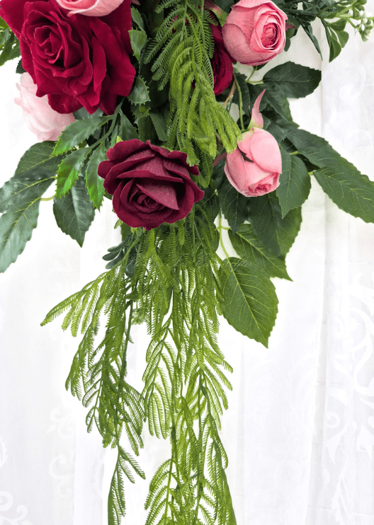 Artificial wedding arbor arrangement detail showing burgundy and pink faux roses above long trailing fern-like foliage. Made in Melbourne by Flowers For Ever After, shipping Australia and Worldwide.