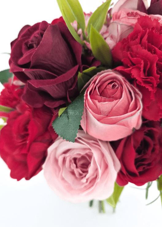 Artificial wedding bouquet close-up with pink and burgundy faux rose petals, red carnation and narrow green leaves. Made in Melbourne by Flowers For Ever After, shipping Australia and Worldwide.