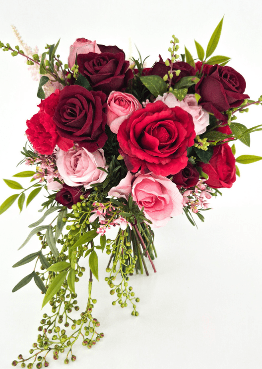 Artificial wedding cascading bridal bouquet with red, burgundy and pink faux roses, red carnations, small pink blossoms and trailing green berry sprigs. Made in Melbourne by Flowers For Ever After, shipping Australia and Worldwide.