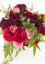 Artificial wedding bridal bouquet, angled view of red, burgundy and pink faux roses, red carnation, variegated green leaves and trailing berry sprigs. Made in Melbourne by Flowers For Ever After, shipping Australia and Worldwide.