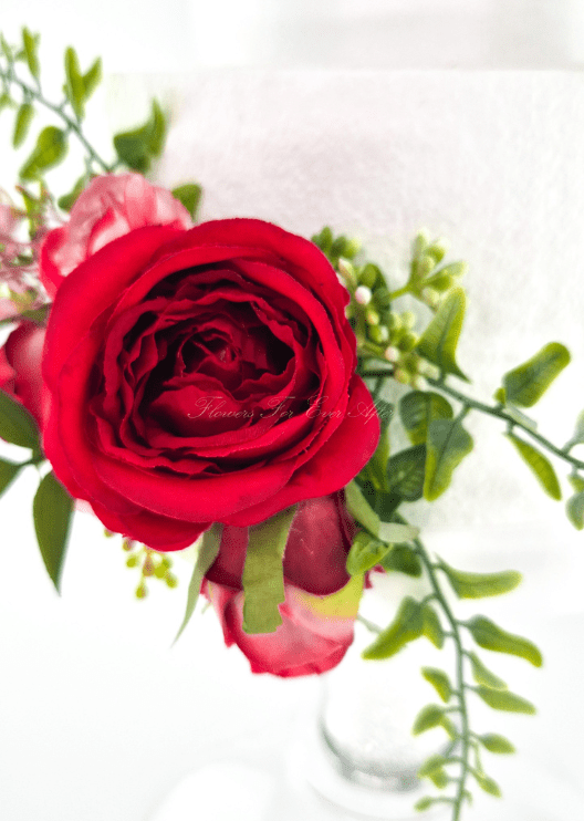 Artificial wedding cake flower close-up with a red faux rose, pink rosebud and bright green sprigs. For birthday, event and celebration cakes. Made in Melbourne by Flowers For Ever After, shipping Australia and Worldwide.