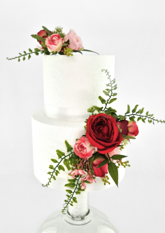 Artificial wedding cake decoration with pink faux roses on top and a red rose cluster with green sprigs on the lower tier. For birthday, event and celebration cakes. Made in Melbourne by Flowers For Ever After, shipping Australia and Worldwide.