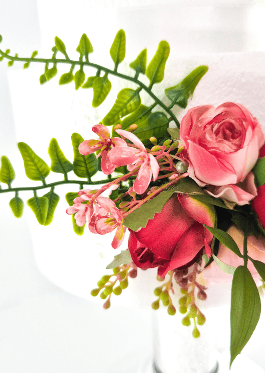 Artificial wedding cake flower detail showing pink and red faux rosebuds, small pink blossoms and green sprigs. For birthday, event and celebration cakes. Made in Melbourne by Flowers For Ever After, shipping Australia and Worldwide.