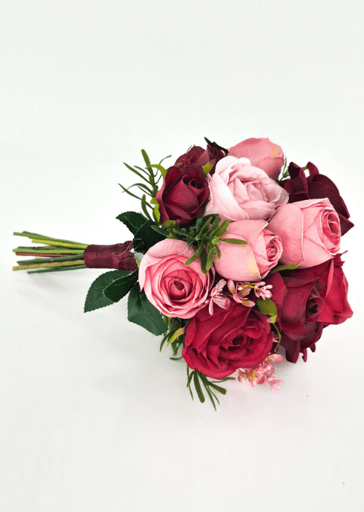 Artificial wedding small bouquet, angled view of pink, red and burgundy faux roses, small pink blossoms and green leaves. Made in Melbourne by Flowers For Ever After, shipping Australia and Worldwide.