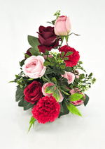 Artificial wedding table arrangement, angled view of pink and burgundy faux roses, red carnations, white flower sprigs and fern-like foliage. Made in Melbourne by Flowers For Ever After, shipping Australia and Worldwide.