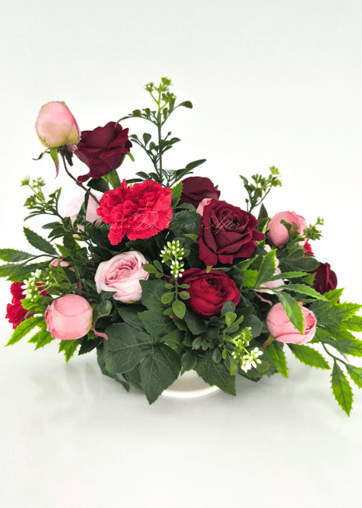 Artificial wedding table centrepiece, front view of pink and burgundy faux roses, red carnations, white flower sprigs and green foliage. Made in Melbourne by Flowers For Ever After, shipping Australia and Worldwide.