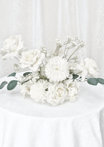 Artificial wedding table centrepiece with white faux roses, white pompom blooms, fine white sprigs and spreading eucalyptus. Made in Melbourne by Flowers For Ever After, shipping Australia and Worldwide.