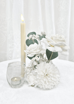 Artificial wedding small table arrangement with white faux roses, white pompom bloom, tiny white sprigs and eucalyptus beside candles. Made in Melbourne by Flowers For Ever After, shipping Australia and Worldwide.
