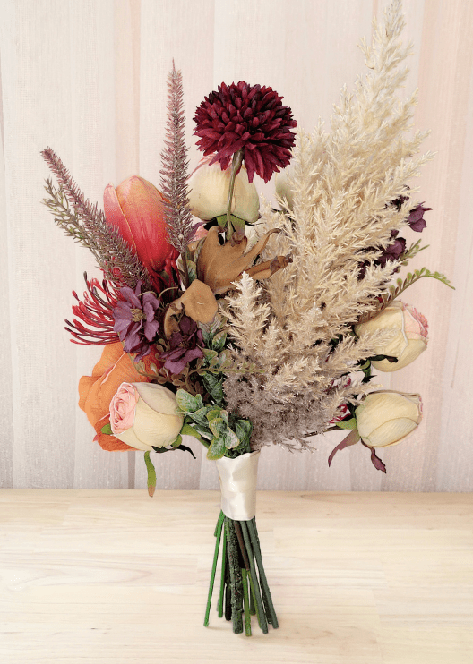 Artificial wedding bouquet, reverse view of cream-pink faux rosebuds, burgundy chrysanthemum, red-orange tulip and pale plumes. Made in Melbourne by Flowers For Ever After, shipping Australia and Worldwide.