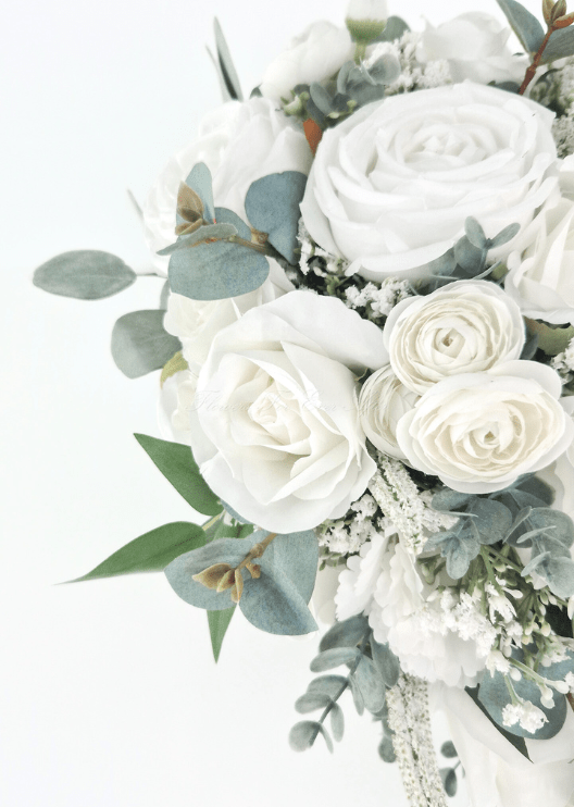 Artificial wedding bouquet close-up with white faux roses, small layered white blooms, tiny filler flowers and rounded eucalyptus leaves. Made in Melbourne by Flowers For Ever After, shipping Australia and Worldwide.