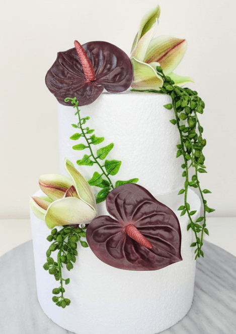 Artificial wedding cake decoration with burgundy faux anthuriums, green-and-burgundy orchids and trailing green strands. For birthday, event and celebration cakes. Made in Melbourne by Flowers For Ever After, shipping Australia and Worldwide.