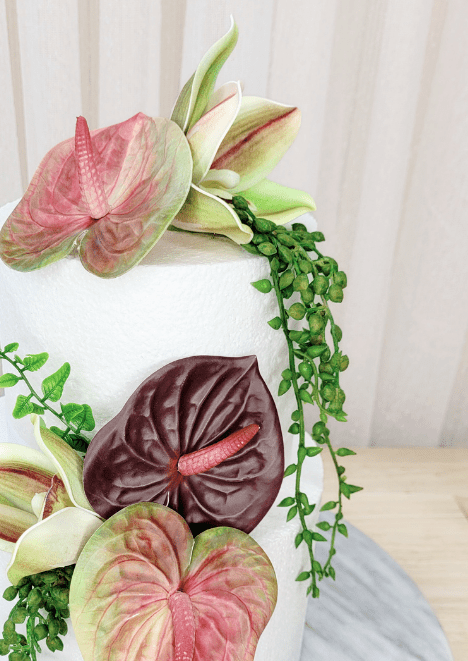 Artificial wedding cake flower close-up with pink-green and burgundy faux anthuriums, green orchids and trailing leaves. For birthday, event and celebration cakes. Made in Melbourne by Flowers For Ever After, shipping Australia and Worldwide.