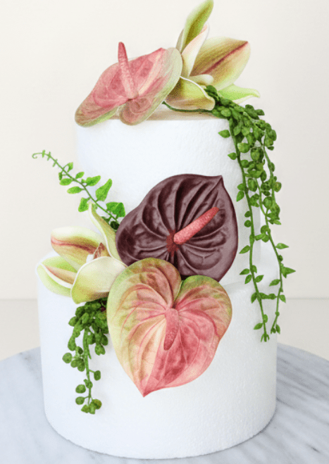 Artificial wedding cake decoration with pink-green and burgundy faux anthuriums, green-and-burgundy orchids and trailing leaves. For birthday, event and celebration cakes. Made in Melbourne by Flowers For Ever After, shipping Australia and Worldwide.