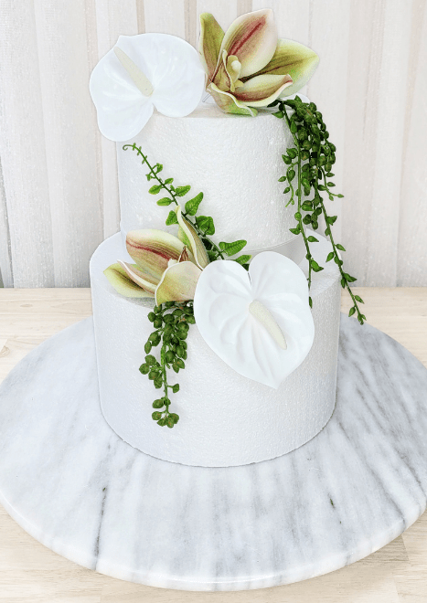Artificial wedding cake decoration, full view of white faux anthuriums, green-and-burgundy orchids and trailing green strands. For birthday, event and celebration cakes. Made in Melbourne by Flowers For Ever After, shipping Australia and Worldwide.