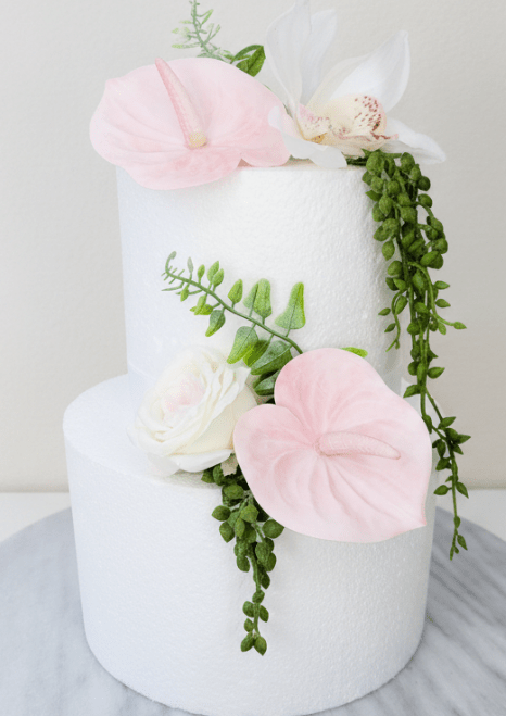 Artificial wedding cake decoration with pale pink faux anthuriums, white speckled orchid, ivory-blush rose and trailing green strands. For birthday, event and celebration cakes. Made in Melbourne by Flowers For Ever After, shipping Australia and Worldwide.