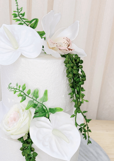 Artificial wedding cake flower close-up with white faux anthuriums, pale speckled orchid, ivory-blush rose and green leaves. For birthday, event and celebration cakes. Made in Melbourne by Flowers For Ever After, shipping Australia and Worldwide.