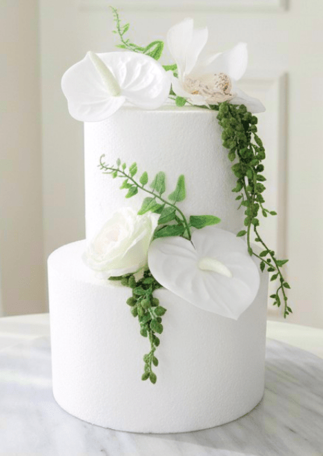 Artificial wedding cake decoration with white faux anthuriums, pale speckled orchid, ivory rose and trailing green strands. For birthday, event and celebration cakes. Made in Melbourne by Flowers For Ever After, shipping Australia and Worldwide.