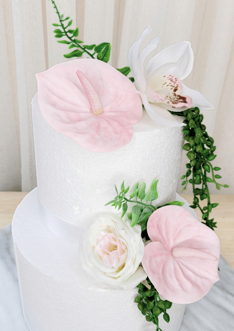 Artificial wedding cake flower close-up with pale pink faux anthuriums, white speckled orchid, ivory-blush rose and green leaves. For birthday, event and celebration cakes. Made in Melbourne by Flowers For Ever After, shipping Australia and Worldwide.