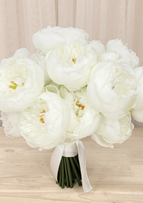 Artificial wedding bridal bouquet, angled view of white faux peonies, golden centres and white ribbon wrapping. Made in Melbourne by Flowers For Ever After, shipping Australia and Worldwide.