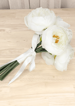 Artificial wedding small bouquet laid sideways, showing white faux peonies, gathered green stems and a white ribbon bow. Made in Melbourne by Flowers For Ever After, shipping Australia and Worldwide.