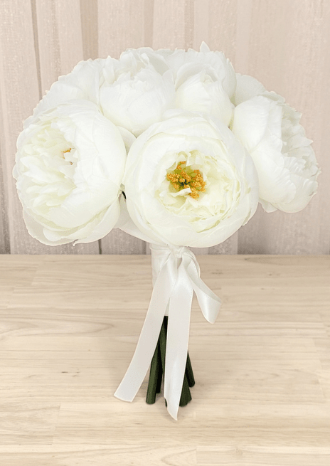 Artificial wedding small bouquet with white faux peonies, golden centres and long white ribbon tails. Made in Melbourne by Flowers For Ever After, shipping Australia and Worldwide.