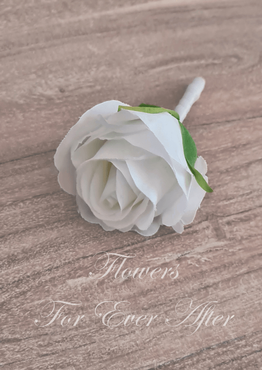 Artificial wedding boutonniere, top view of a white faux rose with green sepals and a white-wrapped stem. For formals, proms and ball occasions. Made in Melbourne by Flowers For Ever After, shipping Australia and Worldwide.