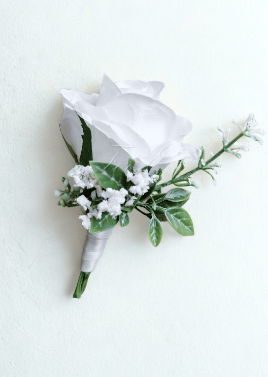 Artificial wedding boutonniere with a white faux rose, tiny white sprigs and variegated green leaves, with ivory-wrapped stems. For formals, proms and ball occasions. Made in Melbourne by Flowers For Ever After, shipping Australia and Worldwide.
