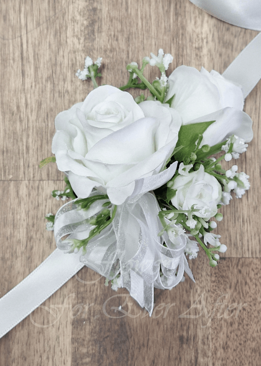 Artificial wedding wrist corsage with a white faux rose, dusty pink rosebuds, pale berries, green leaves and trailing ivory ribbons. For formals, proms and ball occasions. Made in Melbourne by Flowers For Ever After, shipping Australia and Worldwide.