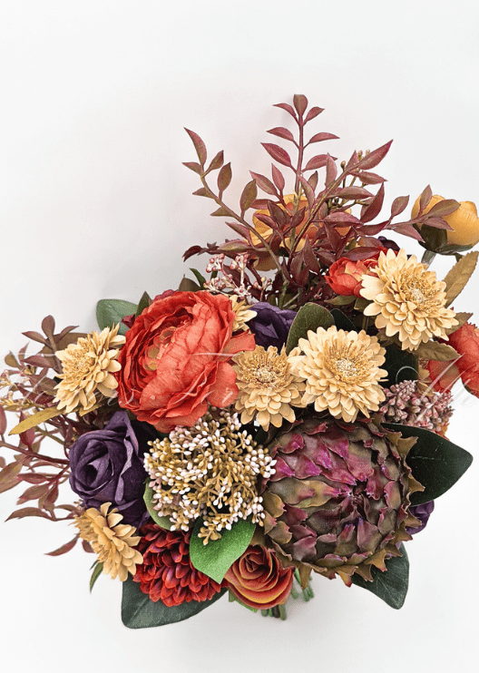 Artificial wedding bridal bouquet, angled view of orange, yellow and burgundy faux flowers with autumn-toned foliage. Made in Melbourne by Flowers For Ever After, shipping Australia and Worldwide.