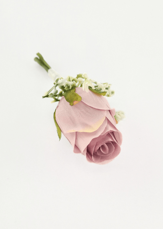 Artificial wedding boutonniere, overhead view of a dusty pink faux rosebud with tiny white flowers and green sepals. For formals, proms and ball occasions. Made in Melbourne by Flowers For Ever After, shipping Australia and Worldwide.