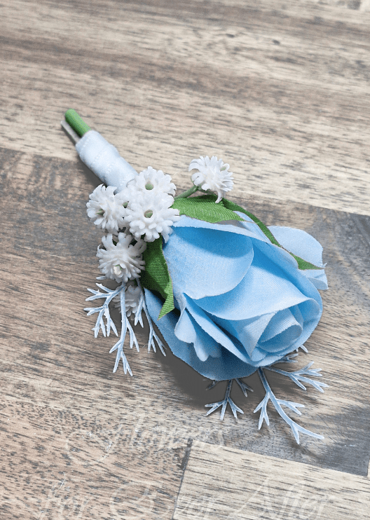 Artificial wedding boutonniere, top view of a light blue faux rose, small white flowers and silver sprigs. For formals, proms and ball occasions. Made in Melbourne by Flowers For Ever After, shipping Australia and Worldwide.