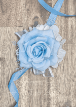 Artificial wedding wrist corsage, angled view of light blue faux roses, white filler flowers and trailing ivory ribbons. For formals, proms and ball occasions. Made in Melbourne by Flowers For Ever After, shipping Australia and Worldwide.