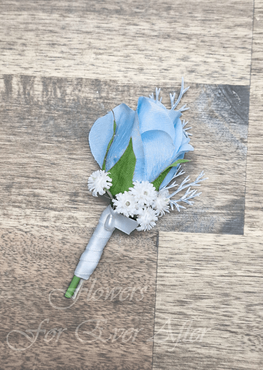 Artificial wedding boutonniere with a light blue faux rose, small white flowers, pale silver sprigs and a white-wrapped stem. For formals, proms and ball occasions. Made in Melbourne by Flowers For Ever After, shipping Australia and Worldwide.