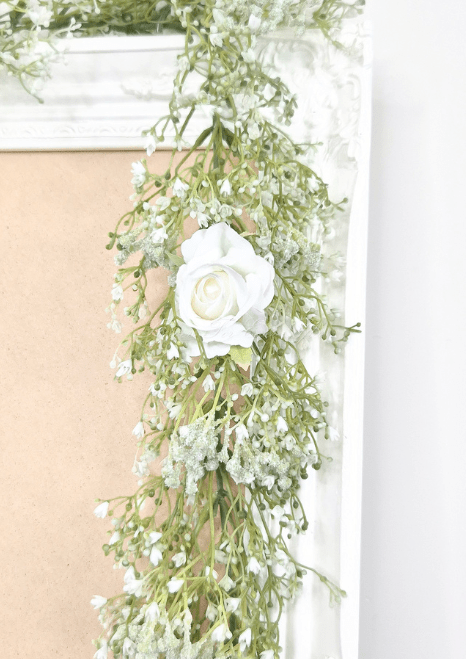 Artificial wedding garland detail showing a white faux rose surrounded by tiny white baby's breath flowers. Made in Melbourne by Flowers For Ever After, shipping Australia and Worldwide.