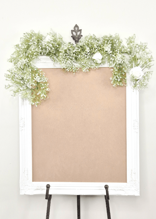 Artificial wedding sign garland with white faux baby's breath and white roses draped across the top corners. Made in Melbourne by Flowers For Ever After, shipping Australia and Worldwide.