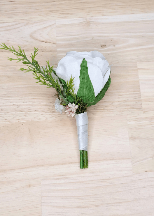Artificial wedding boutonniere, reverse view of a white faux rose, tiny pale flowers and a green sprig with ivory-wrapped stems. For formals, proms and ball occasions. Made in Melbourne by Flowers For Ever After, shipping Australia and Worldwide.