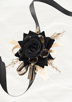 Artificial wedding wrist corsage, full view of a black faux rose, amber jewels, golden sprigs and long black ribbon tails. For formals, proms and ball occasions. Made in Melbourne by Flowers For Ever After, shipping Australia and Worldwide.