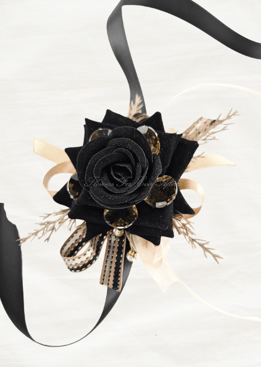 Artificial wedding wrist corsage, full view of a black faux rose, amber jewels, golden sprigs and long black ribbon tails. For formals, proms and ball occasions. Made in Melbourne by Flowers For Ever After, shipping Australia and Worldwide.