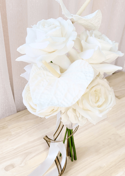 Artificial wedding bridesmaid bouquet, angled view of white faux anthuriums, roses and ranunculus with long ribbons. Made in Melbourne by Flowers For Ever After, shipping Australia and Worldwide.