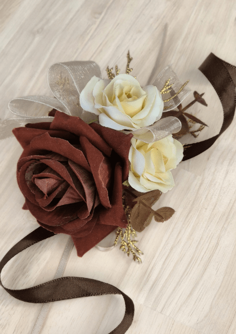 Artificial wedding wrist corsage with brown and ivory faux roses, golden sprigs, brown eucalyptus and ivory and brown ribbons. For formals, proms and ball occasions. Made in Melbourne by Flowers For Ever After, shipping Australia and Worldwide.