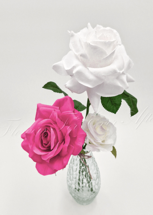 Artificial wedding table arrangement, angled view of faux roses and green leaves in a glass bottle. Made in Melbourne by Flowers For Ever After, shipping Australia and Worldwide.