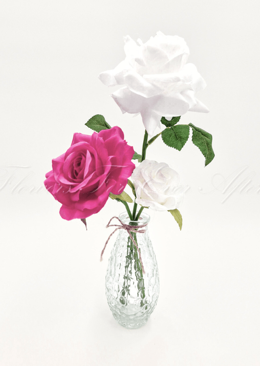Artificial wedding table arrangement with faux roses and green foliage in a clear glass bottle. Made in Melbourne by Flowers For Ever After, shipping Australia and Worldwide.