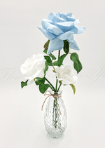 Artificial wedding table arrangement with faux roses and green leaves in a clear glass bottle. Made in Melbourne by Flowers For Ever After, shipping Australia and Worldwide.