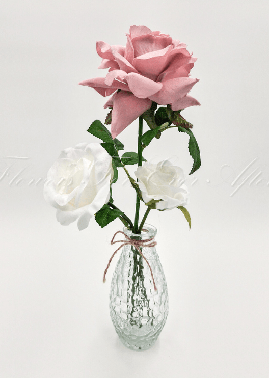 Artificial wedding table arrangement with faux roses and green foliage in a glass bottle. Made in Melbourne by Flowers For Ever After, shipping Australia and Worldwide.